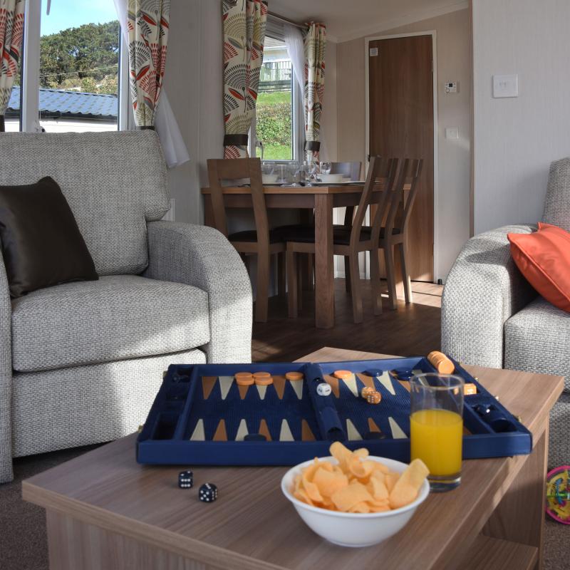Games and snacks on the table in the lounge of an Atlantic Gold Caravan at Woolacombe Sands Holiday Park