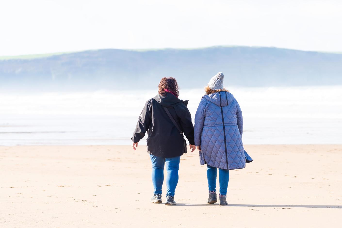 Guests from Woolacombe Sands Holiday Park walking along Woolacombe Beach on an Autumn Day