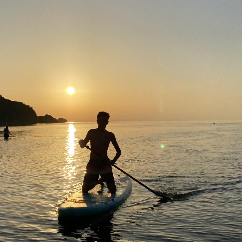 Family paddle boarding SUP at a Combe Martin sunset
