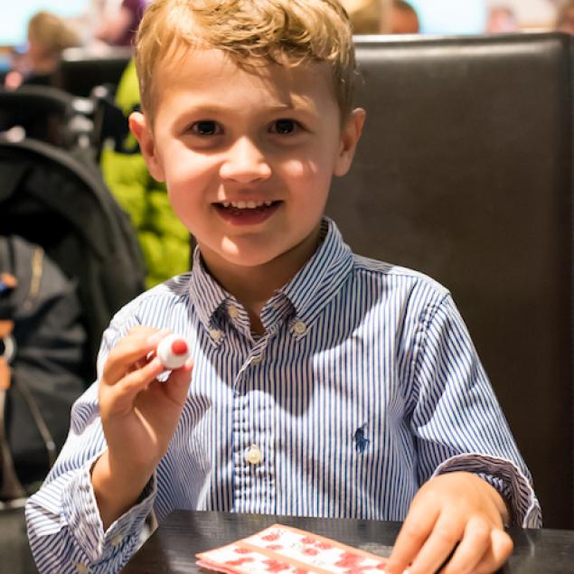 Young boy helps Mum and Dad play bingo at Woolacombe Sands Holiday Park