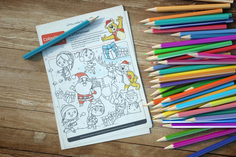 A Christmas colouring sheet for kids with colouring pencils around it